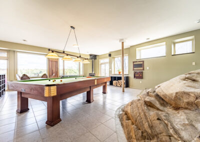 Recreation room with pool table and large windows.